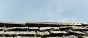 damaged residential roof showing worn shingles and structural wear
